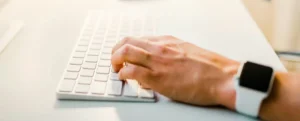 Uma pessoa mexendo em um iMac