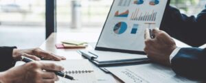 Colaboradores de uma empresa acompanhando resultados em um gráfico e fazendo anotações