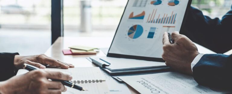 Colaboradores de uma empresa acompanhando resultados em um gráfico e fazendo anotações